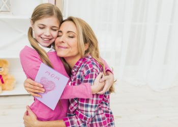 happy-mother-with-greeting-card-hugging-daughter